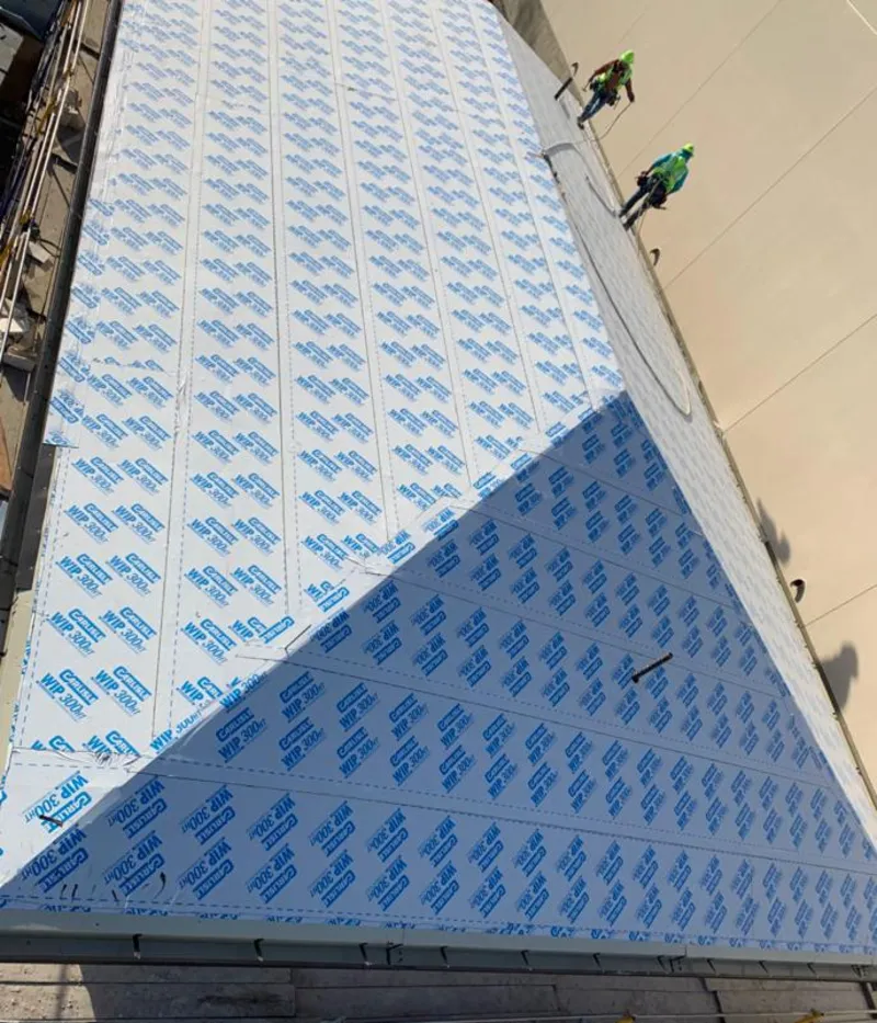 Professional roofers installing underlayment on a metal roof in University Park